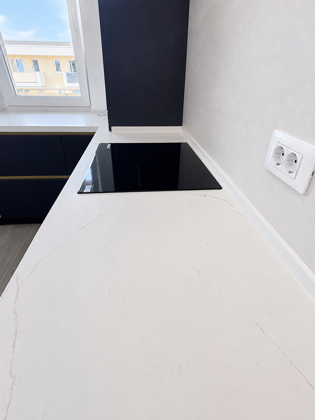 Mobilier de bucătărie NORVINIA, cu fronturi din MDF termoformat albastre și textură lemn, blat din cuarț compozit și mânere tip profil GOLA, finisaj auriu