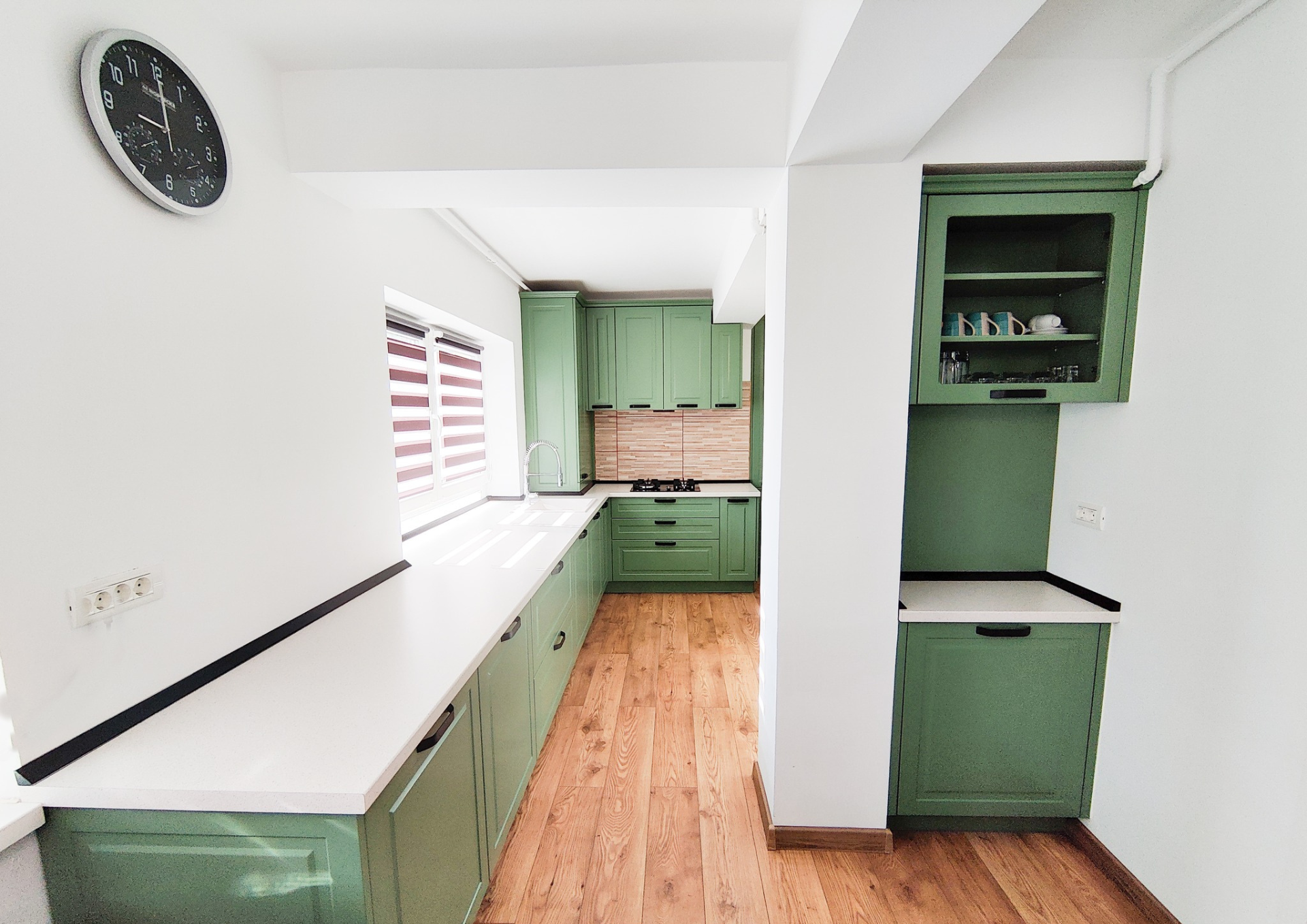 Mobila bucătărie fabricată la comandă de NORVINIA cu blat în L, cu îmbinare invizibilă, blat și glaf geam din același material, mobilier din MDF termoformat