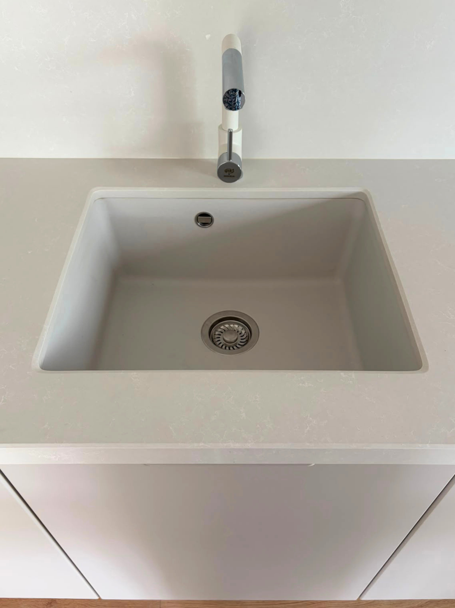 Mobilier de bucătărie din MDF termoformat, cu blat din cuarț și mânere aplicate
