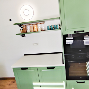 Mobila bucătărie fabricată la comandă de NORVINIA cu blat în L, cu îmbinare invizibilă, blat și glaf geam din același material, mobilier din MDF termoformat