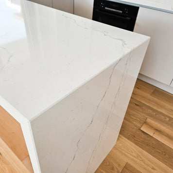 Mobilă de bucătărie fabricată la comandă de NORVINIA cu blat și glaf geam din cuarț compozit, mobilier din MDF termoformat