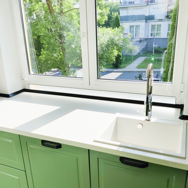 Mobila bucătărie fabricată la comandă de NORVINIA cu blat în L, cu îmbinare invizibilă, blat și glaf geam din același material, mobilier din MDF termoformat