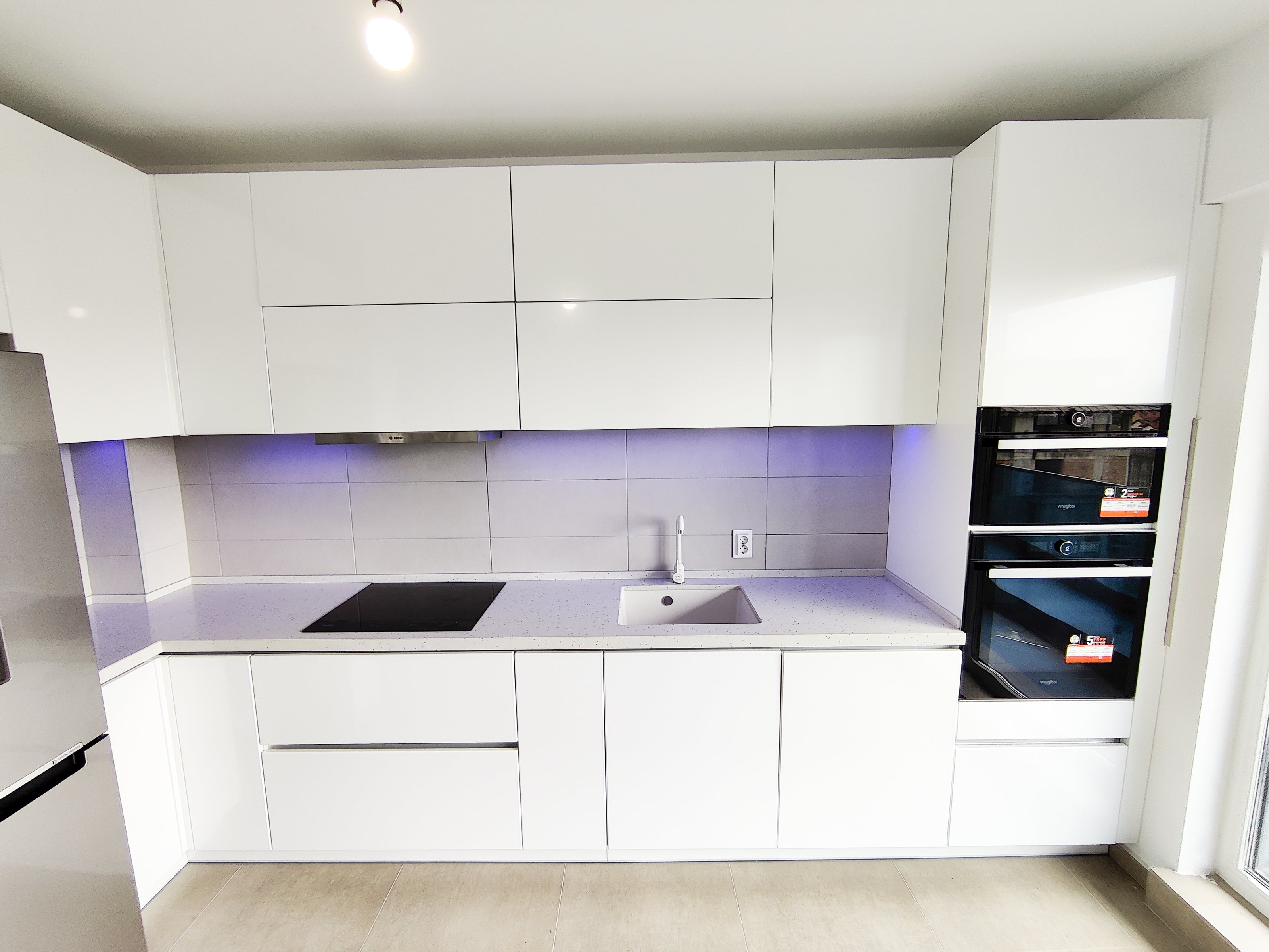 Mobilier bucătărie NORVINIA, cu mânere Gola ascunse în spatele ușilor, blat din cuarț compozit și chiuvetă montată sub blat