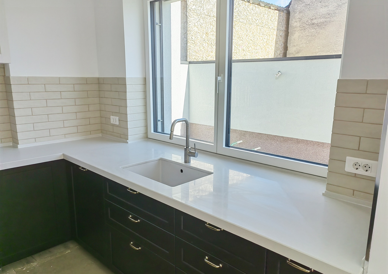 Blat din cuarț compozit NORVINIA, blat bucătărie și glaf geam din același material, chiuvetă montată sub blat, îmbinare blat în 