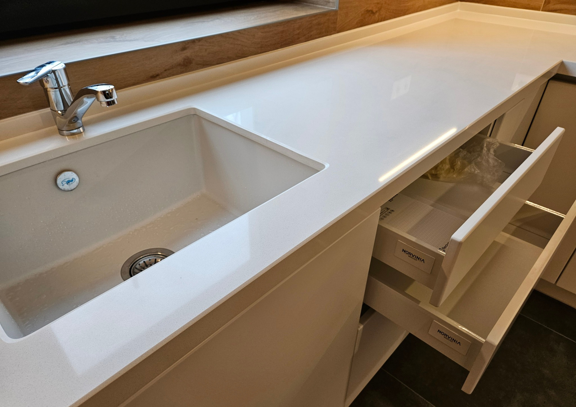 Mobilă bucătărie fabricată la comandă de NORVINIA din MDF termoformat, blat din cuarț compozit cu chiuvetă montată sub blat