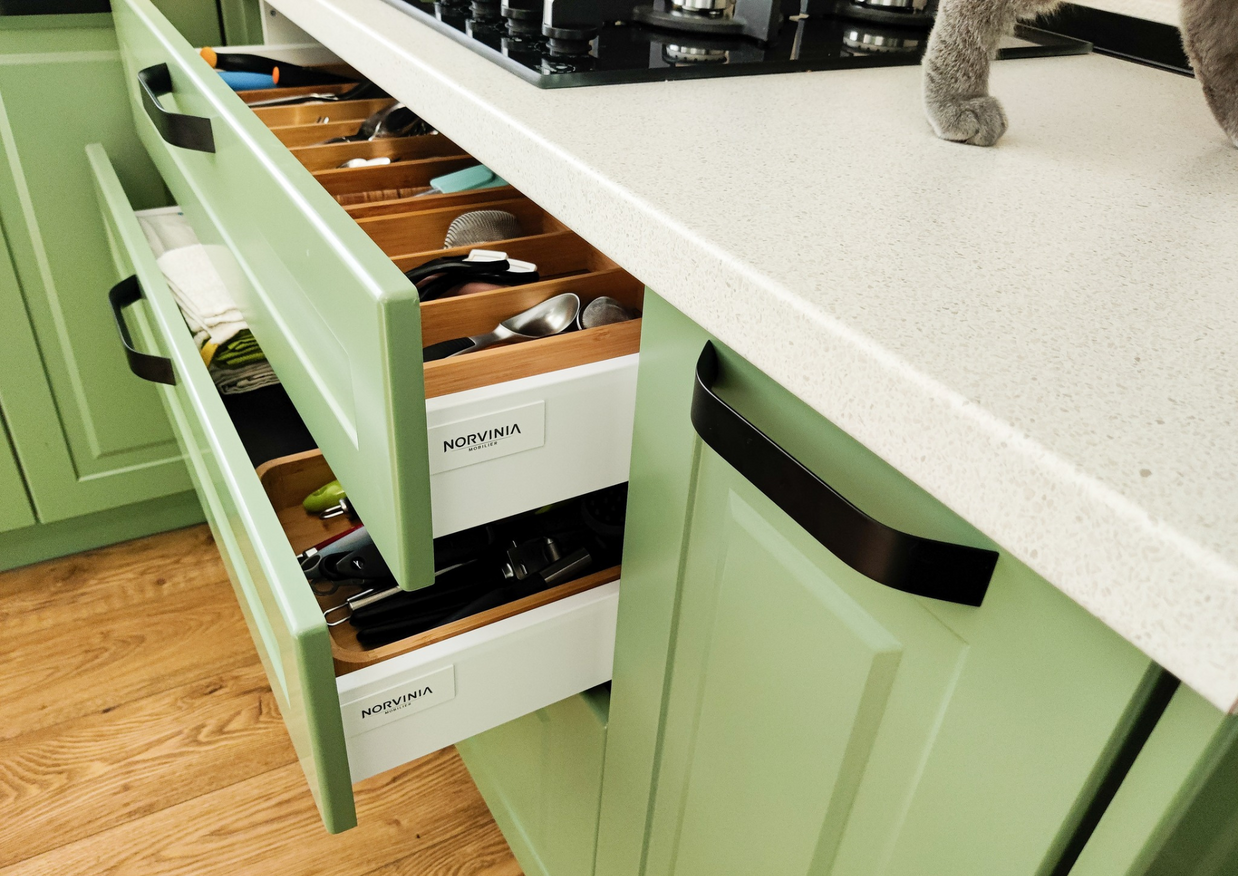 Mobila bucătărie fabricată la comandă de NORVINIA cu blat în L, cu îmbinare invizibilă, blat și glaf geam din același material, mobilier din MDF termoformat