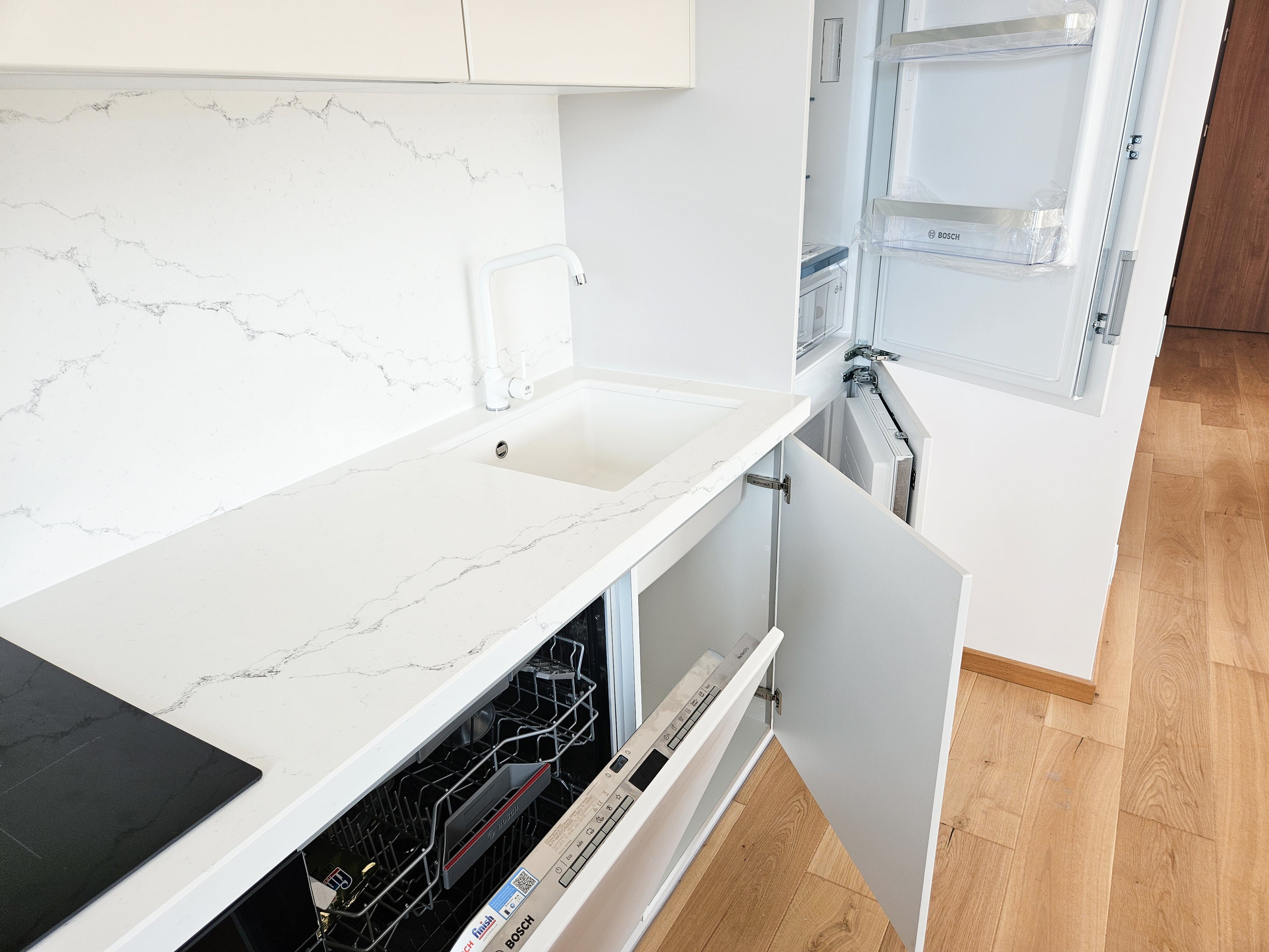 Mobilă de bucătărie fabricată la comandă de NORVINIA cu blat și glaf geam din cuarț compozit, mobilier din MDF termoformat