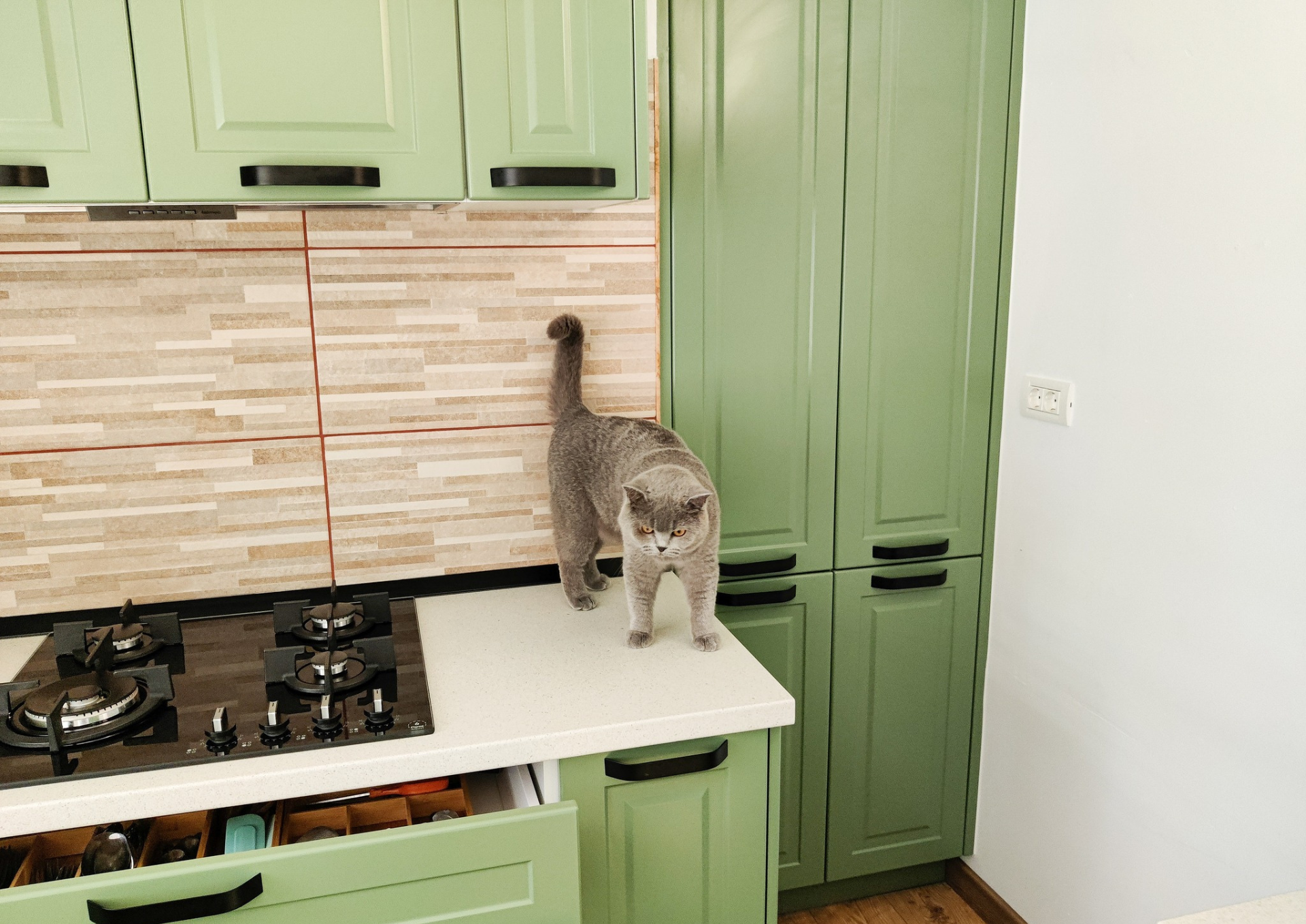 Mobila bucătărie fabricată la comandă de NORVINIA cu blat în L, cu îmbinare invizibilă, blat și glaf geam din același material, mobilier din MDF termoformat