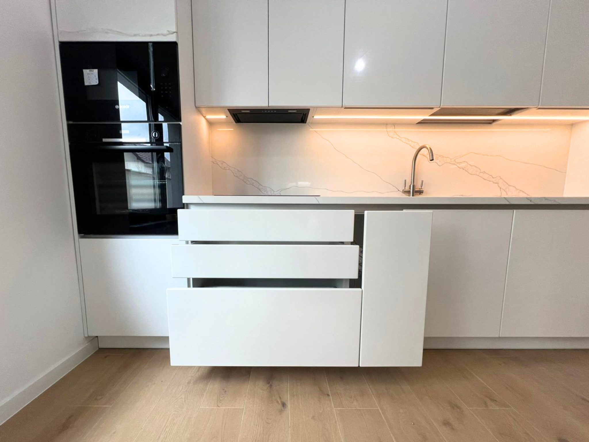 Mobilier de bucătărie NORVINIA, cu fronturi albe din MDF termoformat și mânere tip profil GOLA și blat din cuarț compozit