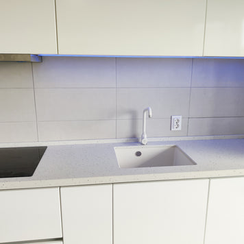 Mobilier bucătărie NORVINIA, cu mânere Gola ascunse în spatele ușilor, blat din cuarț compozit și chiuvetă montată sub blat