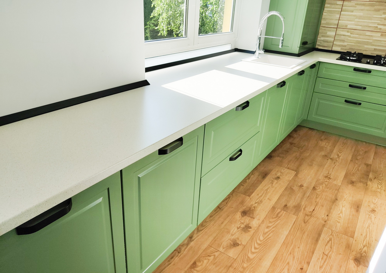 Mobila bucătărie fabricată la comandă de NORVINIA cu blat în L, cu îmbinare invizibilă, blat și glaf geam din același material, mobilier din MDF termoformat