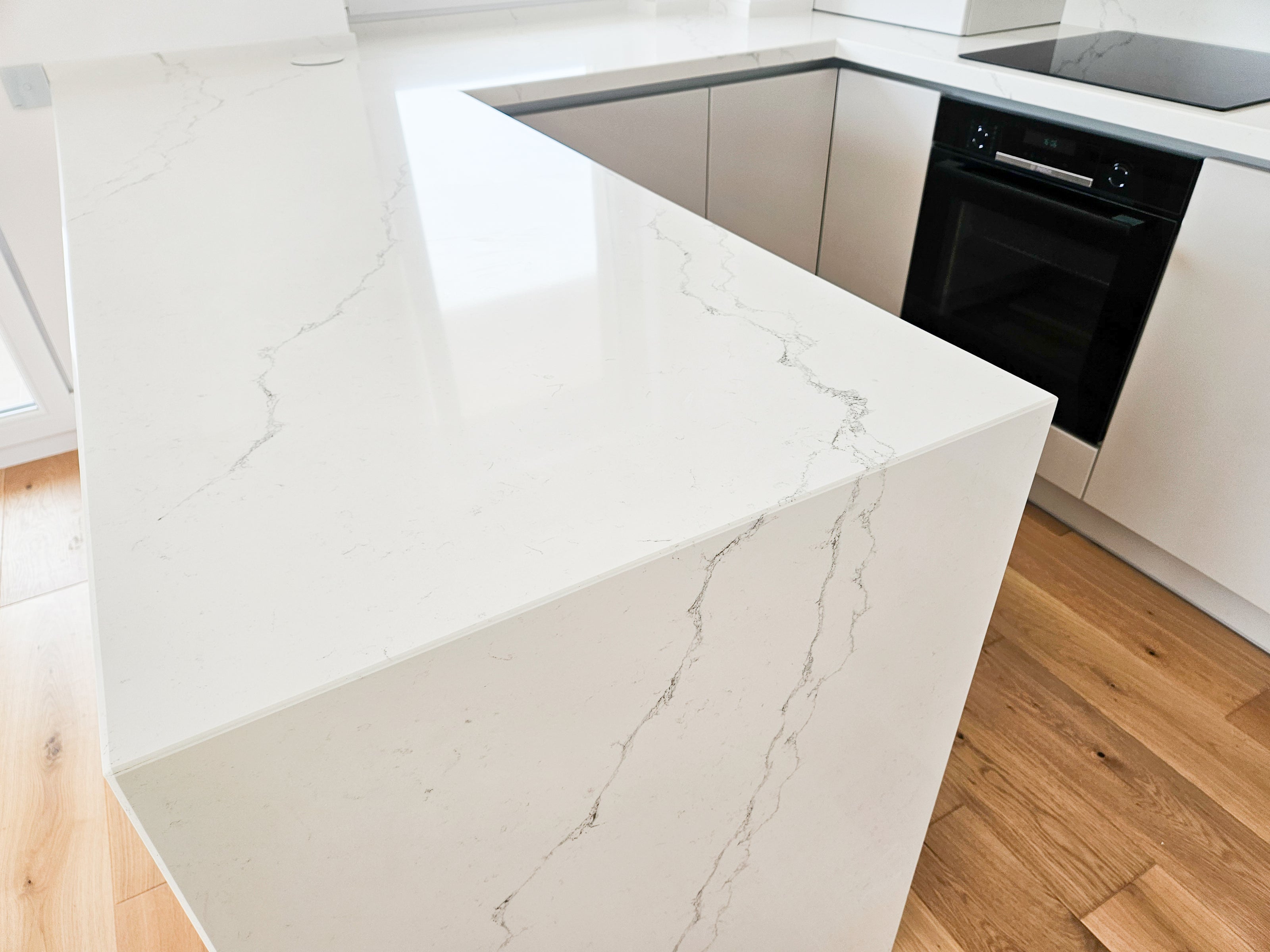 Mobilă de bucătărie fabricată la comandă de NORVINIA cu blat și glaf geam din cuarț compozit, mobilier din MDF termoformat