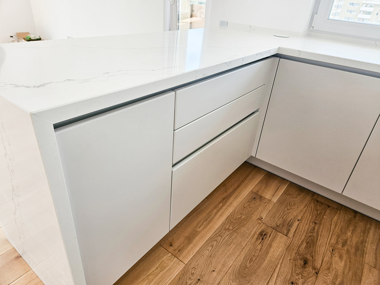 Mobilă de bucătărie fabricată la comandă de NORVINIA cu blat și glaf geam din cuarț compozit, mobilier din MDF termoformat