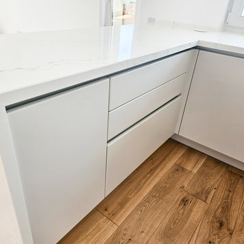 Mobilă de bucătărie fabricată la comandă de NORVINIA cu blat și glaf geam din cuarț compozit, mobilier din MDF termoformat