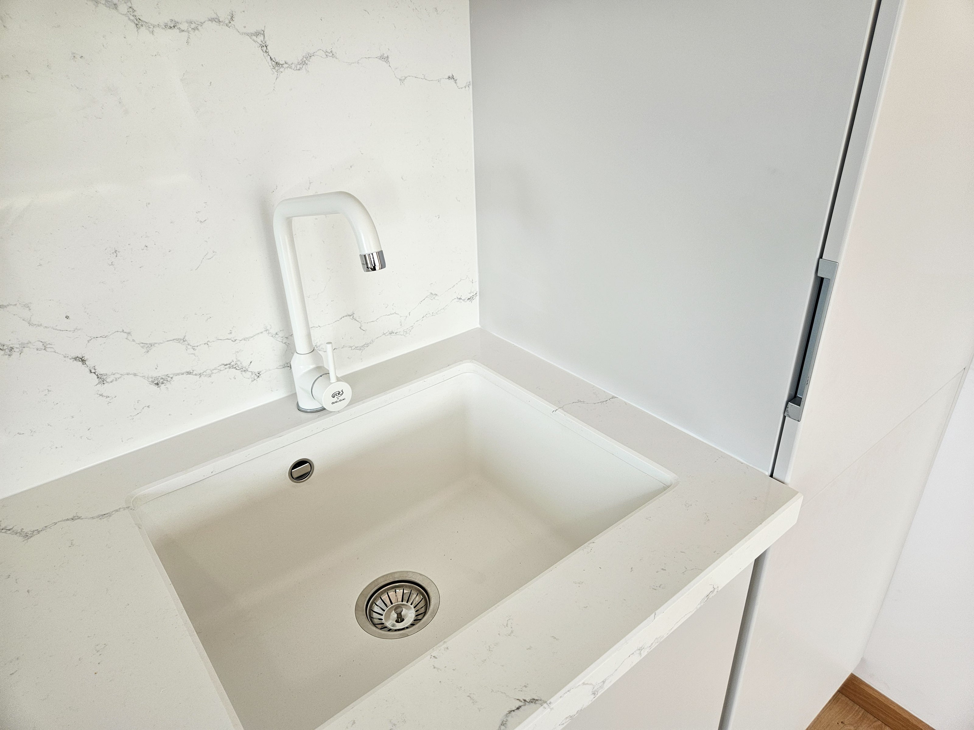 Mobilă de bucătărie fabricată la comandă de NORVINIA cu blat și glaf geam din cuarț compozit, mobilier din MDF termoformat